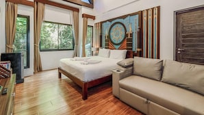 Ein Schlafzimmer mit einem Bett, einer Couch, einem großen Fenster und einer Wanddekoration.