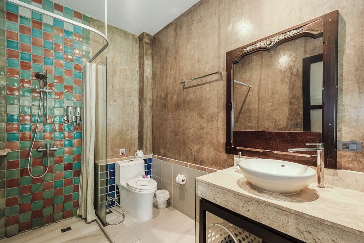 A bathroom with a glass shower enclosure, a white sink, and a large mirror.