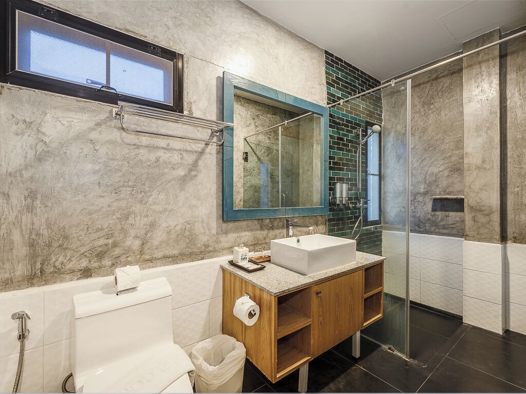 A modern bathroom with a freestanding bathtub, a wooden vanity with a sink, a large mirror, and a glass shower enclosure.
