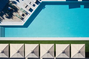 Una piscina al aire libre, sillones reclinables de piscina