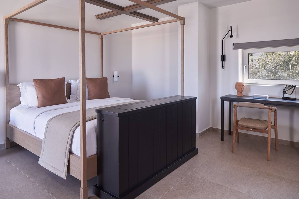 Une chambre à coucher avec un lit à baldaquin, un bureau et une chaise.