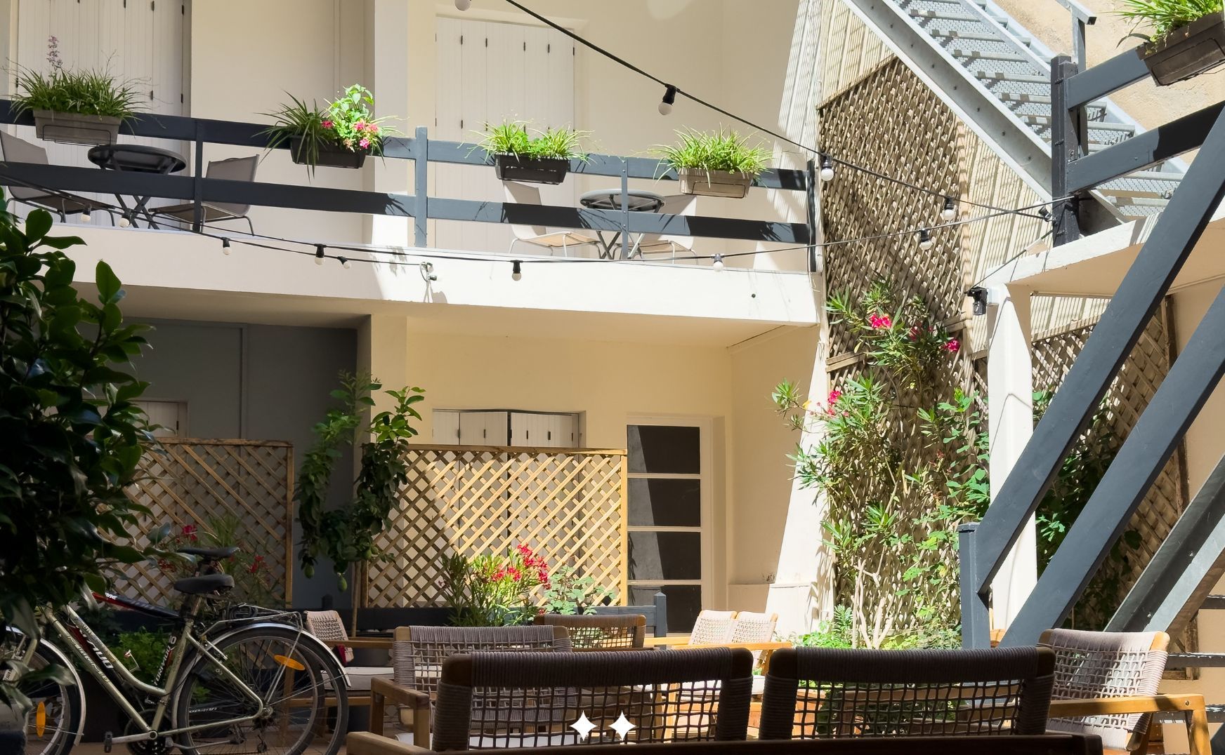 A courtyard with outdoor seating, a bicycle, and potted plants.