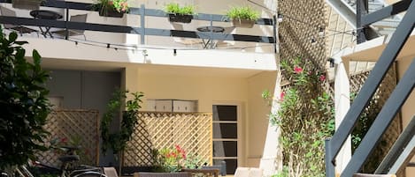 A courtyard with outdoor seating, a bicycle, and potted plants.