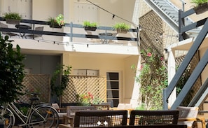 A courtyard with outdoor seating, a bicycle, and potted plants. - Hôtel de Paris (La Rochelle)