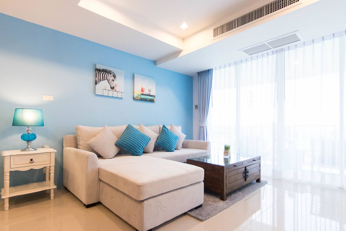 A modern living room with a sofa set, a coffee table, and artwork on the wall.