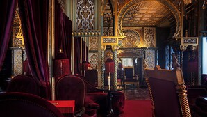 An ornate interior with red velvet chairs, a chandelier, and intricate wall designs. - Maison Souquet, Hotel & Spa (Paris)