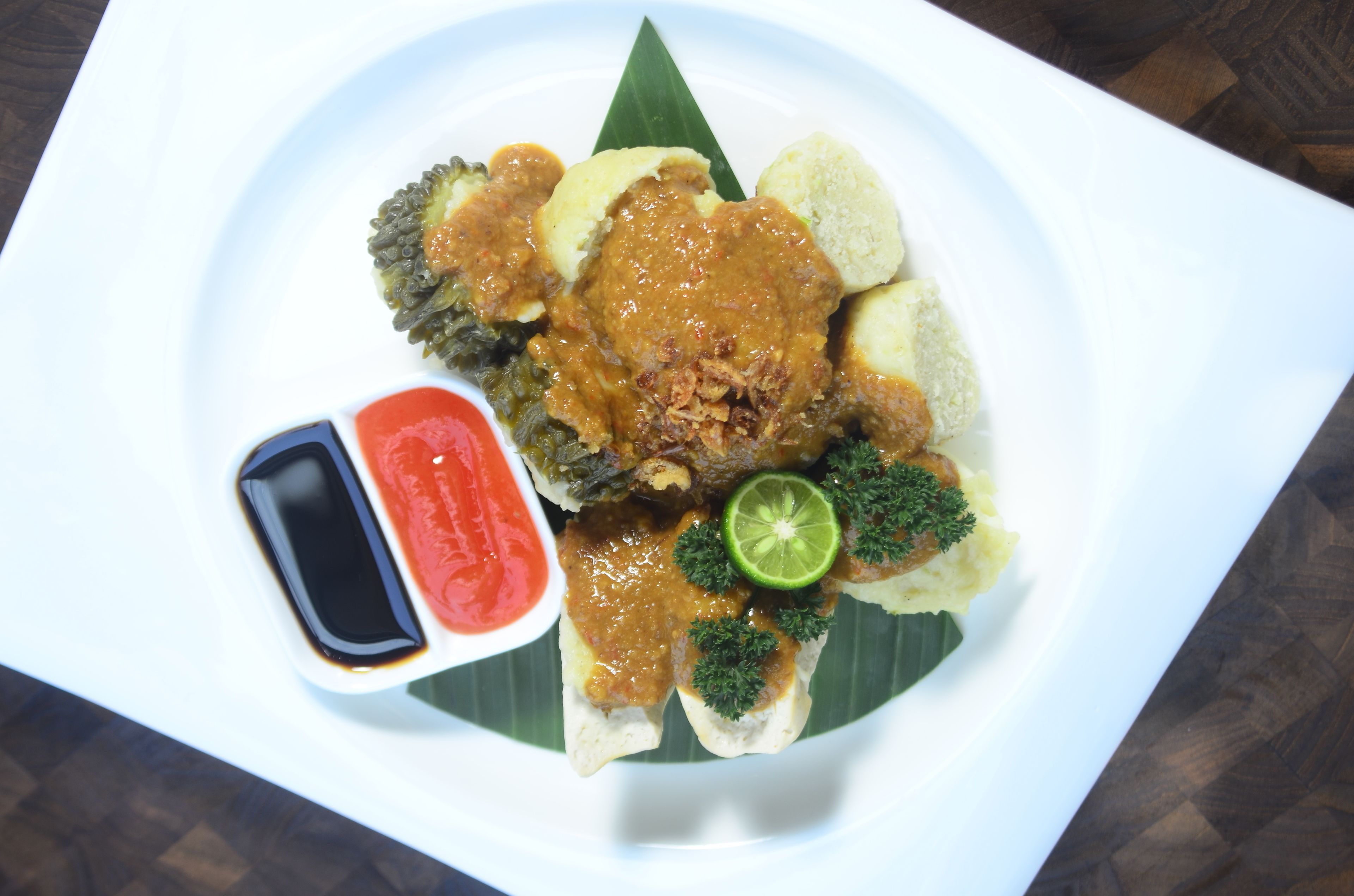 A plate of food with various items including a main dish, side dishes, and sauces.