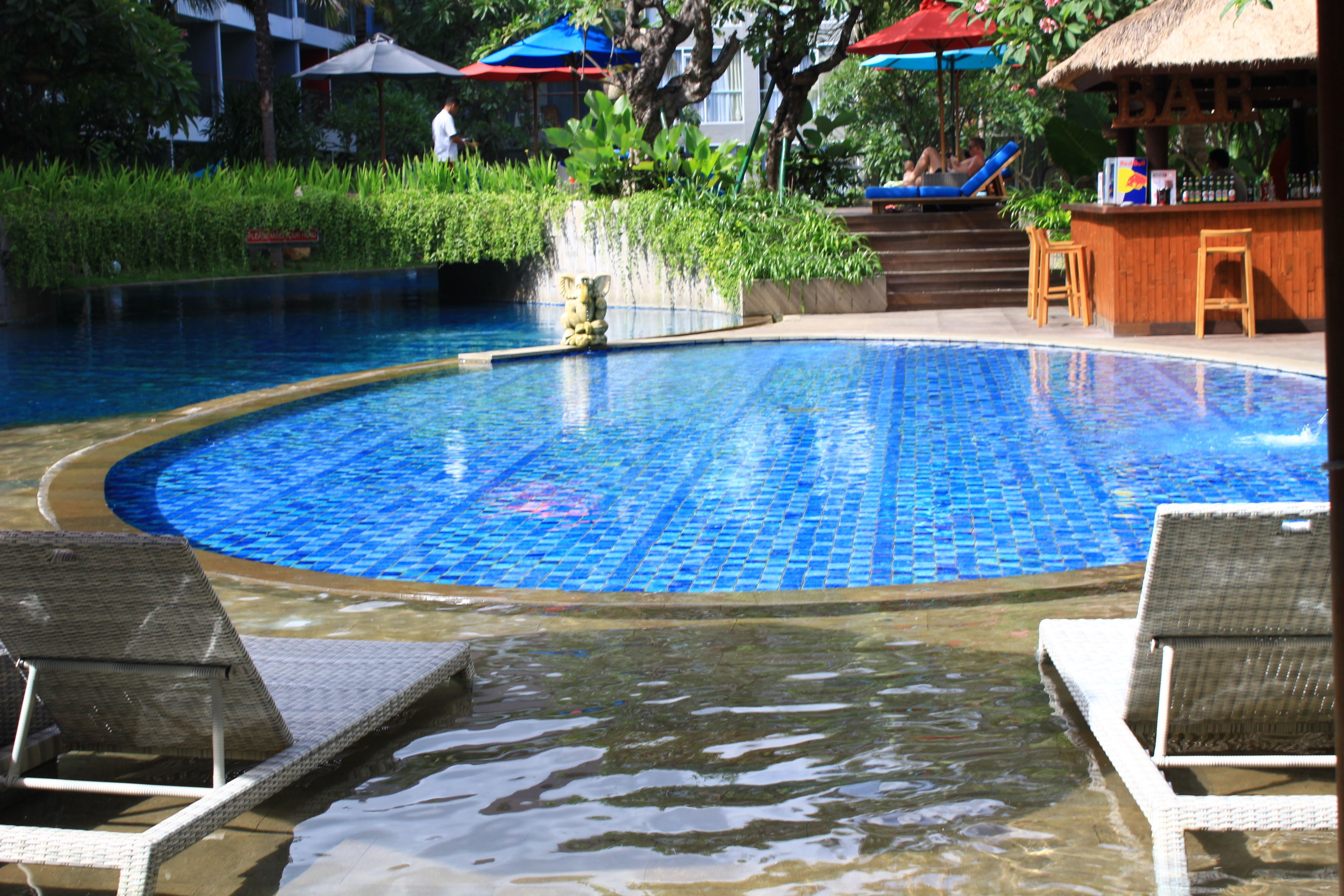 Piscina com espreguiçadeiras e área de bar.