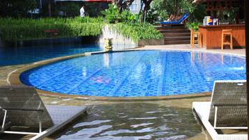 Piscina com espreguiçadeiras e área de bar.