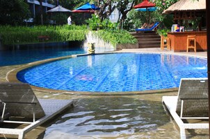 Piscina com espreguiçadeiras e área de bar.