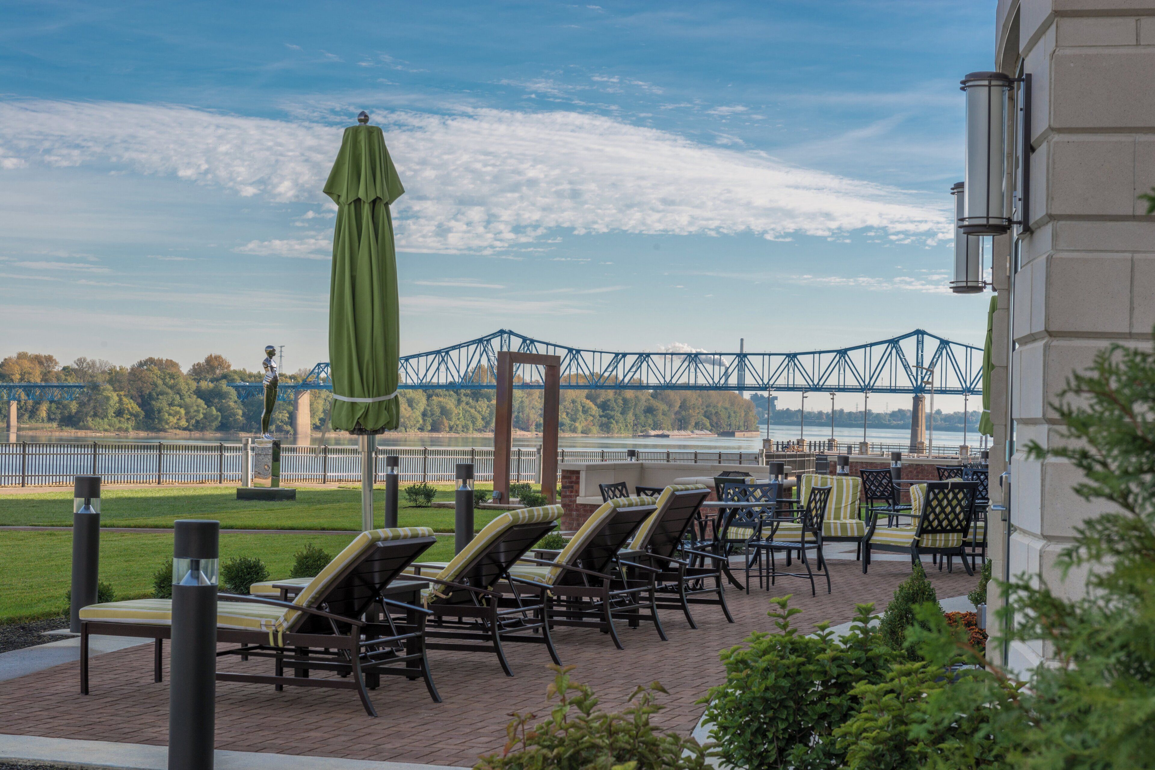 A patio area with outdoor seating and a view of a bridge.