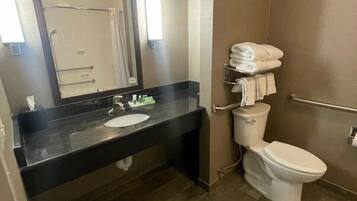 A modern bathroom with a black countertop sink, a white toilet, and a glass shower enclosure.