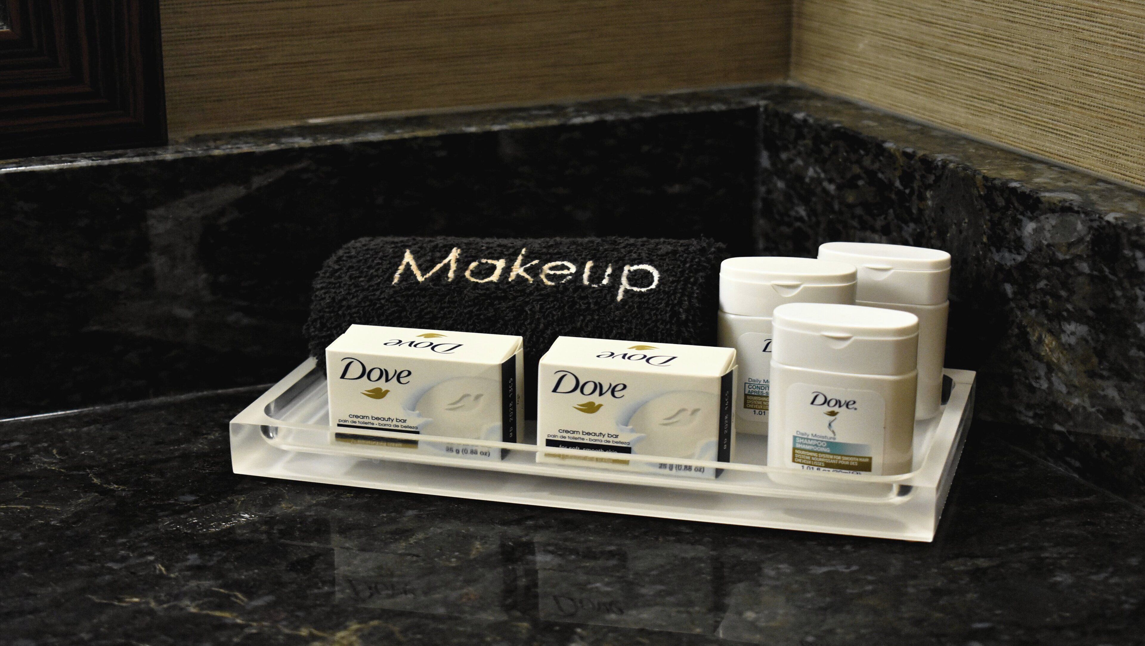 Un espacio de maquillaje con productos Dove sobre una encimera de mármol.