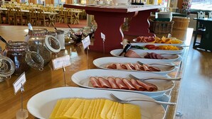 A buffet with various food items including cheese, ham, and other dishes. - Hotell Moskogen (Leksand)