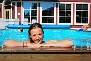Una piscina al aire libre, sombrillas, sillones reclinables de piscina