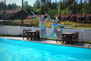 Una piscina al aire libre, sombrillas, sillones reclinables de piscina