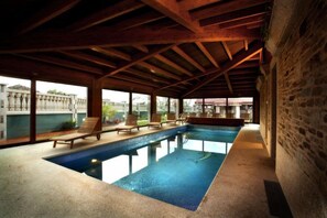 Een binnenzwembad en ligstoelen