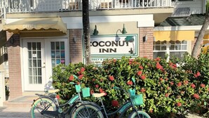 Un edificio con un letrero que dice 'Coconut Inn' y una bicicleta estacionada adelante.
