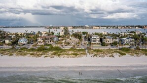 A coastal residential area with beachfront properties, a sandy beach, and a view of the ocean. - Sabal Palms Inn (St. Pete Beach)