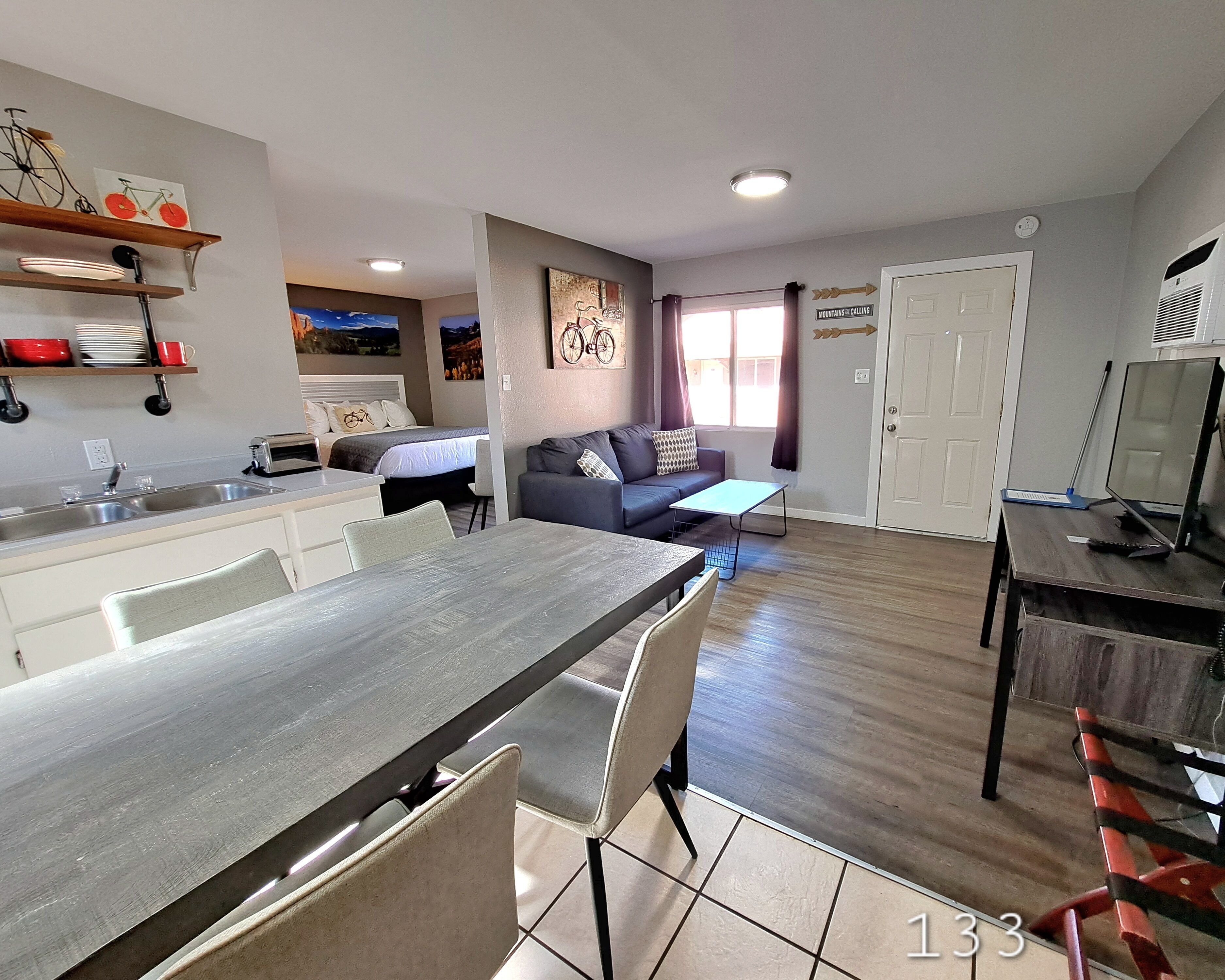 Una sala de estar moderna con comedor, cocina y dormitorio.
