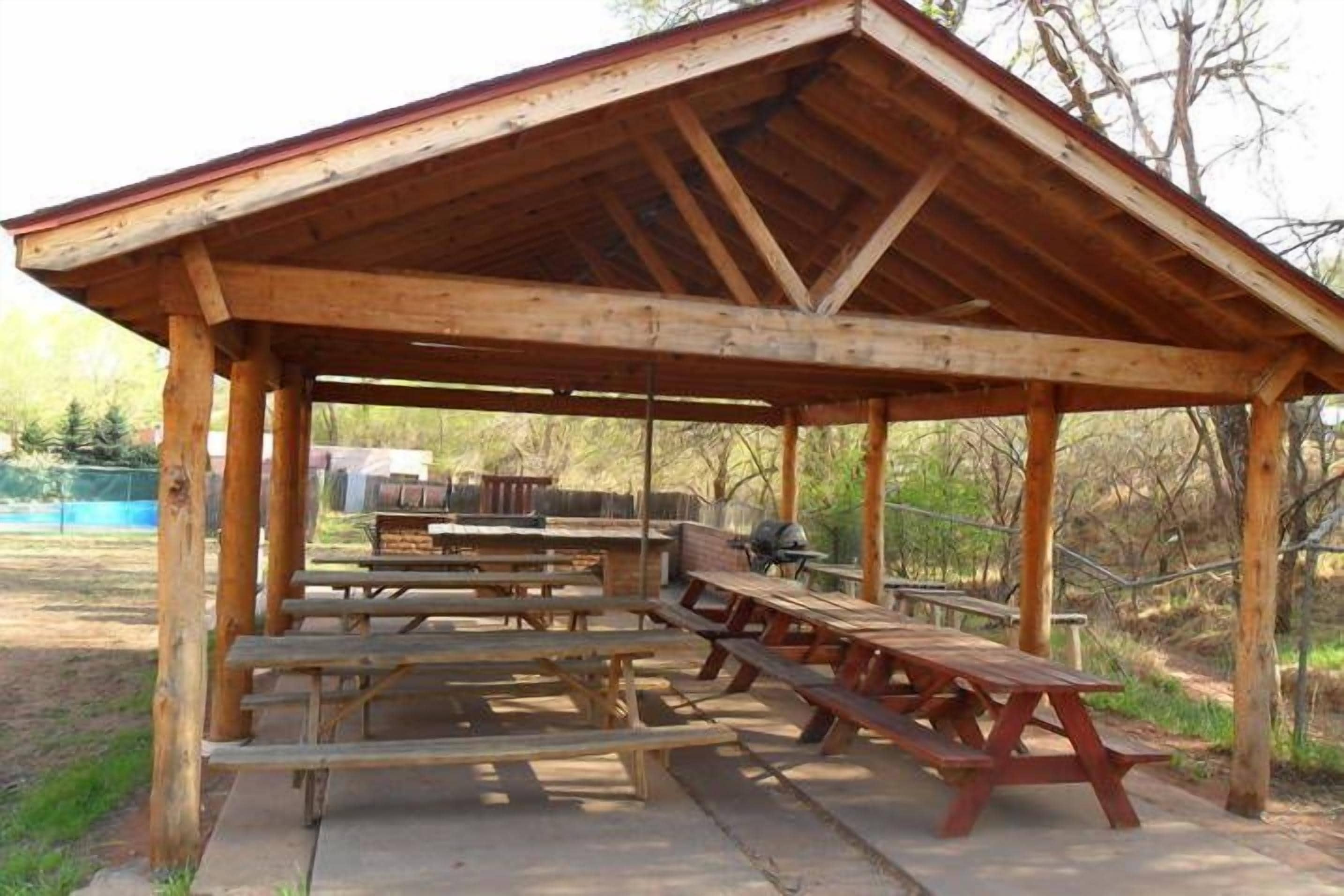 Ein hölzerner Pavillon mit Picknicktischen.