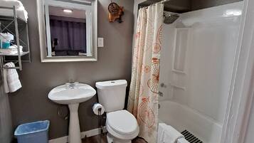 Un baño con lavamanos, inodoro y ducha.