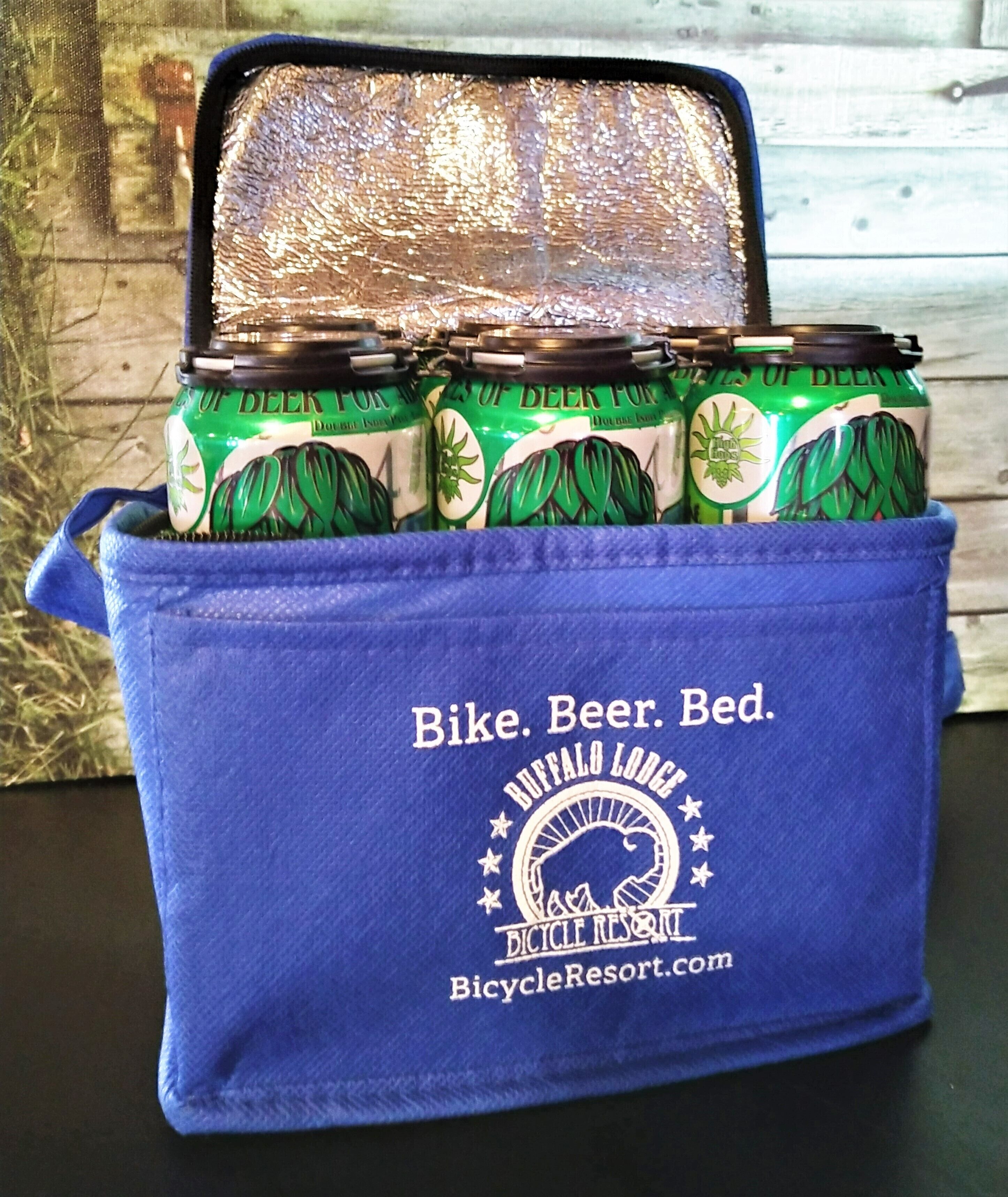 Una bolsa azul con latas de cerveza y el logo de Buffalo Lodge Bicycle Resort.