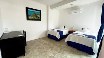 Una habitación de hotel con dos camas, un escritorio y un cuadro en la pared.