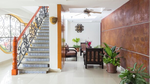Un interior moderno con escalera, zona de estar y decoración en la pared.