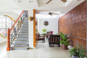 Un intérieur moderne avec un escalier, un coin salon et un mur décoratif.