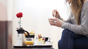 A breakfast setup with a coffee pot, a glass of orange juice, a plate with a red flower, and a cup of coffee. - Ibis Bandung Pasteur (Bandung)