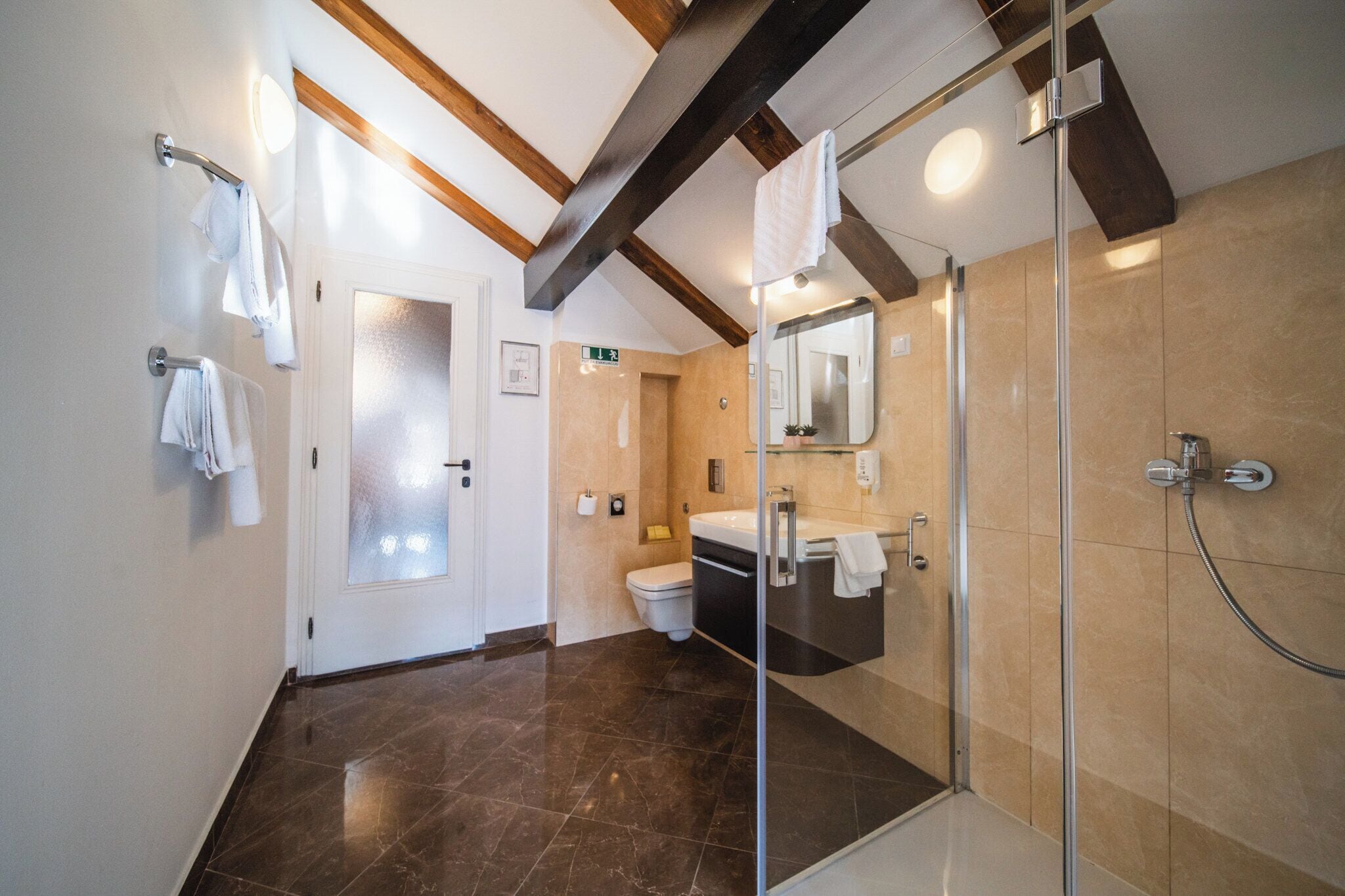 A modern bathroom with a glass shower enclosure, a sink, and a toilet.