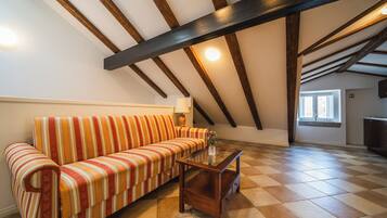 A cozy living room with a striped sofa, a wooden coffee table, and a checkered floor.