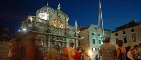 A historic building with a dome and stained glass windows, surrounded by people.