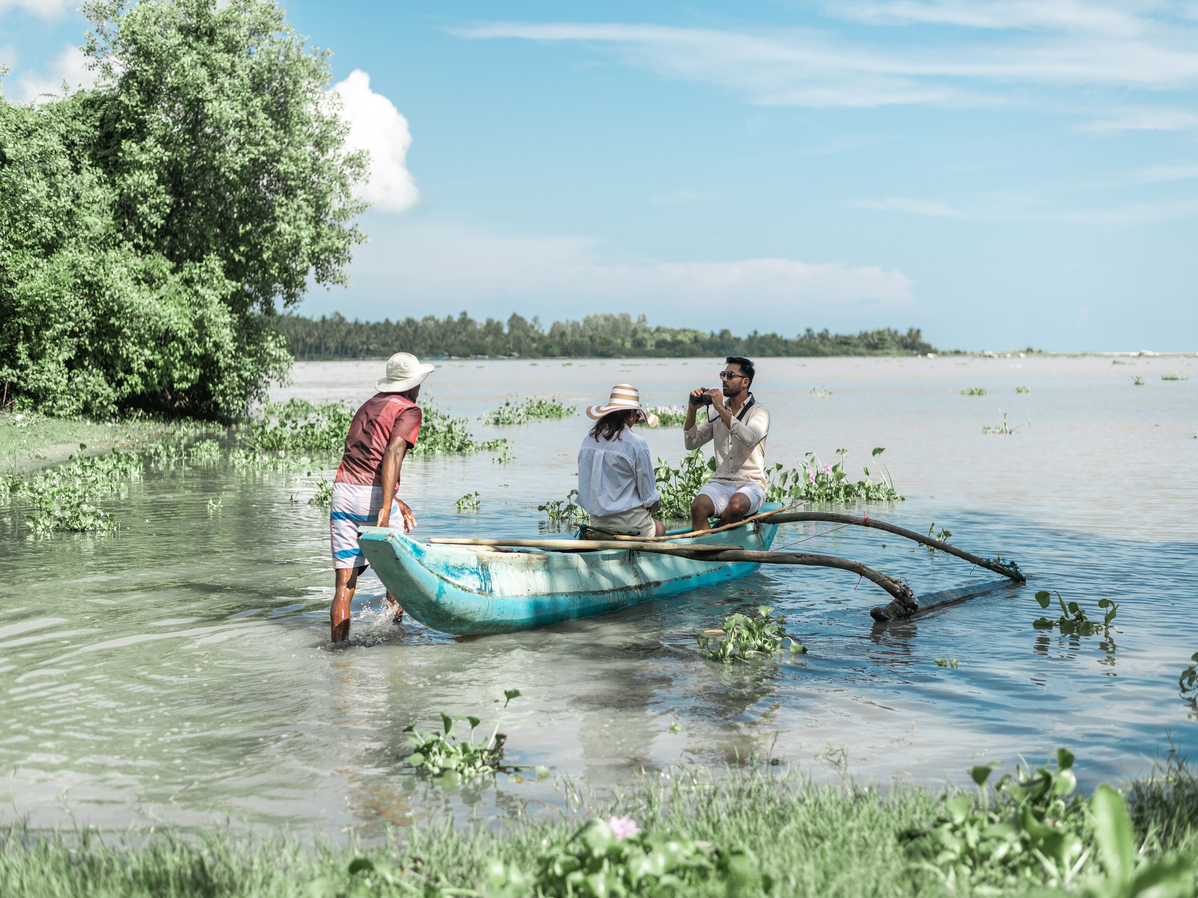 A boat on a calm body of water surrounded by greenery.