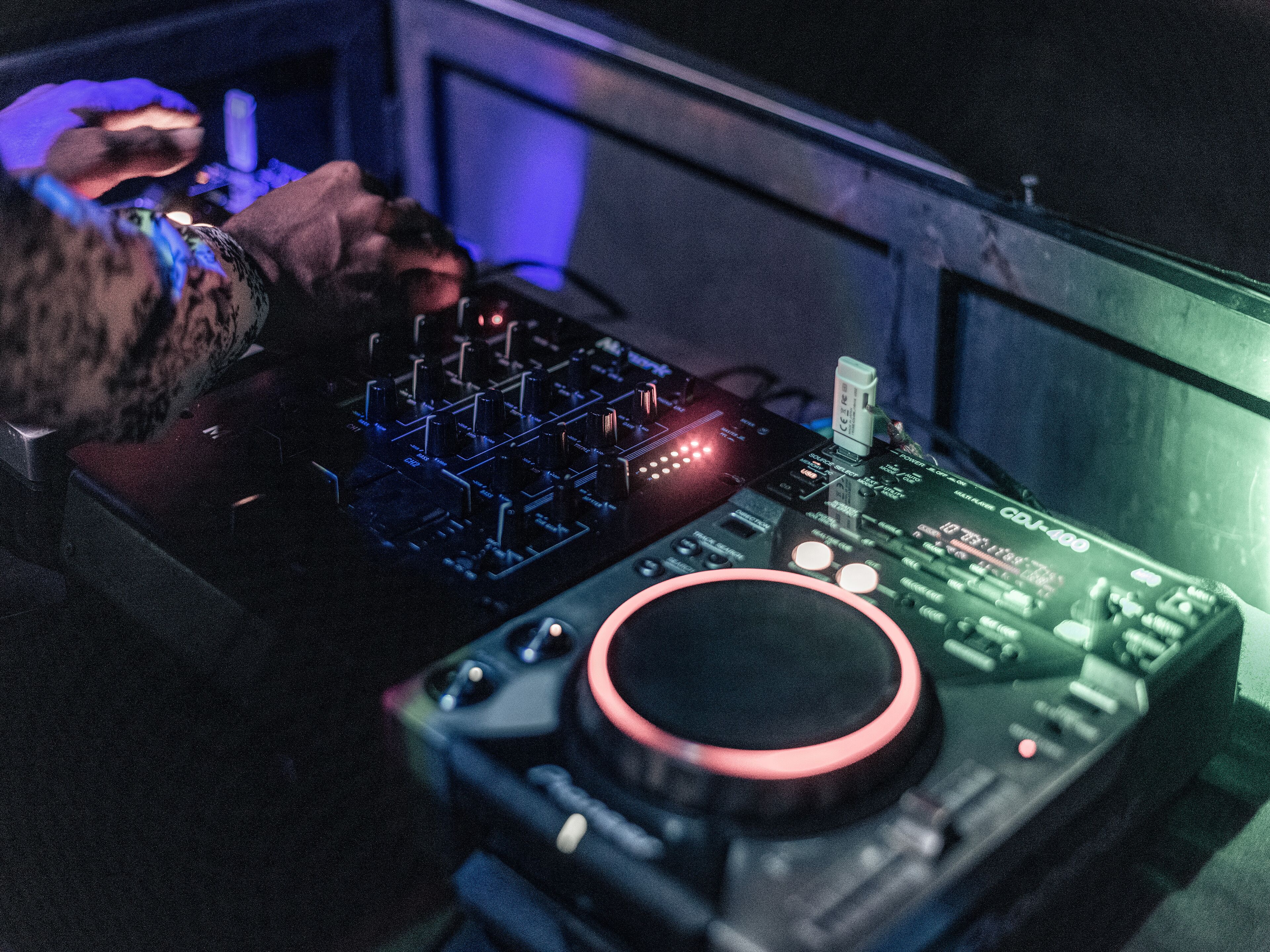 Una mesa de mezclas de DJ con múltiples perillas y controles deslizantes, un puerto USB y un interruptor de encendido.