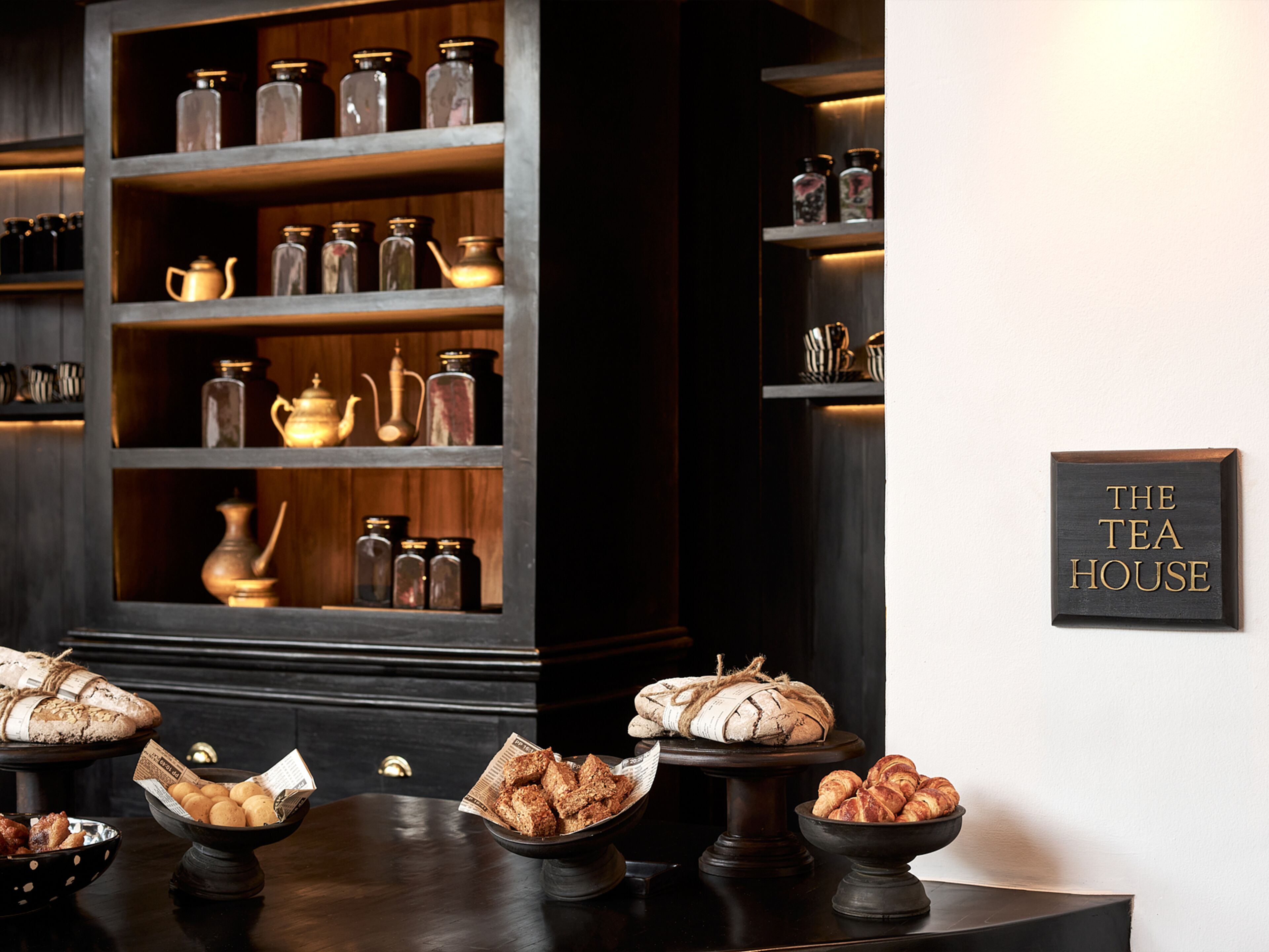 A tea house with shelves of tea jars and a sign on the wall.