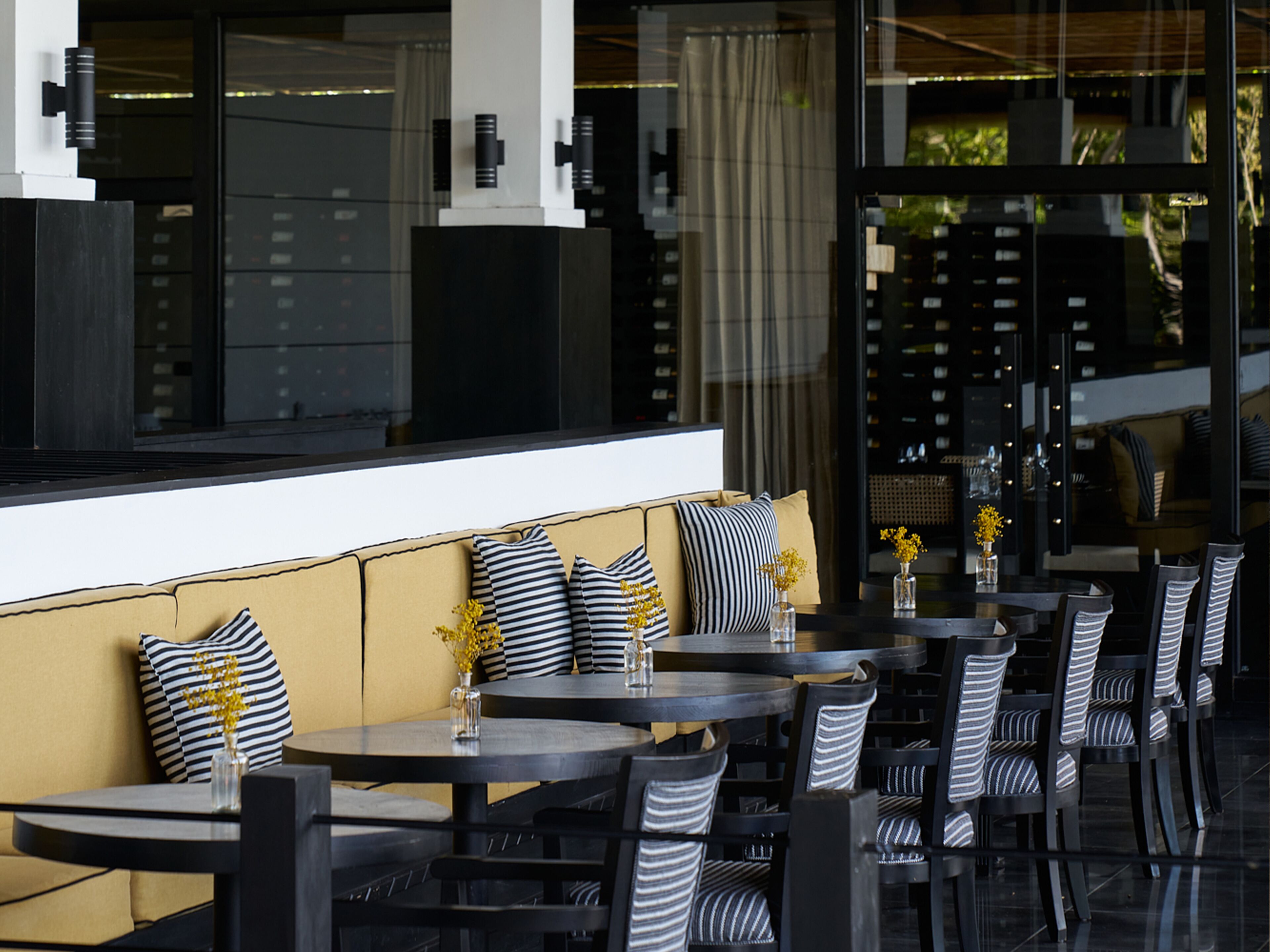 An outdoor seating area with a sofa and tables, chairs, and decorative vases.