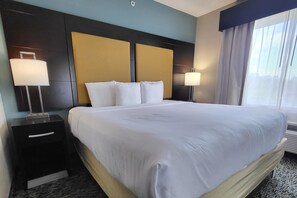 A hotel room with a large bed, two bedside tables, and a window with curtains. - Comfort Suites Fort Lauderdale Airport South & Cruise Port (Dania Beach)