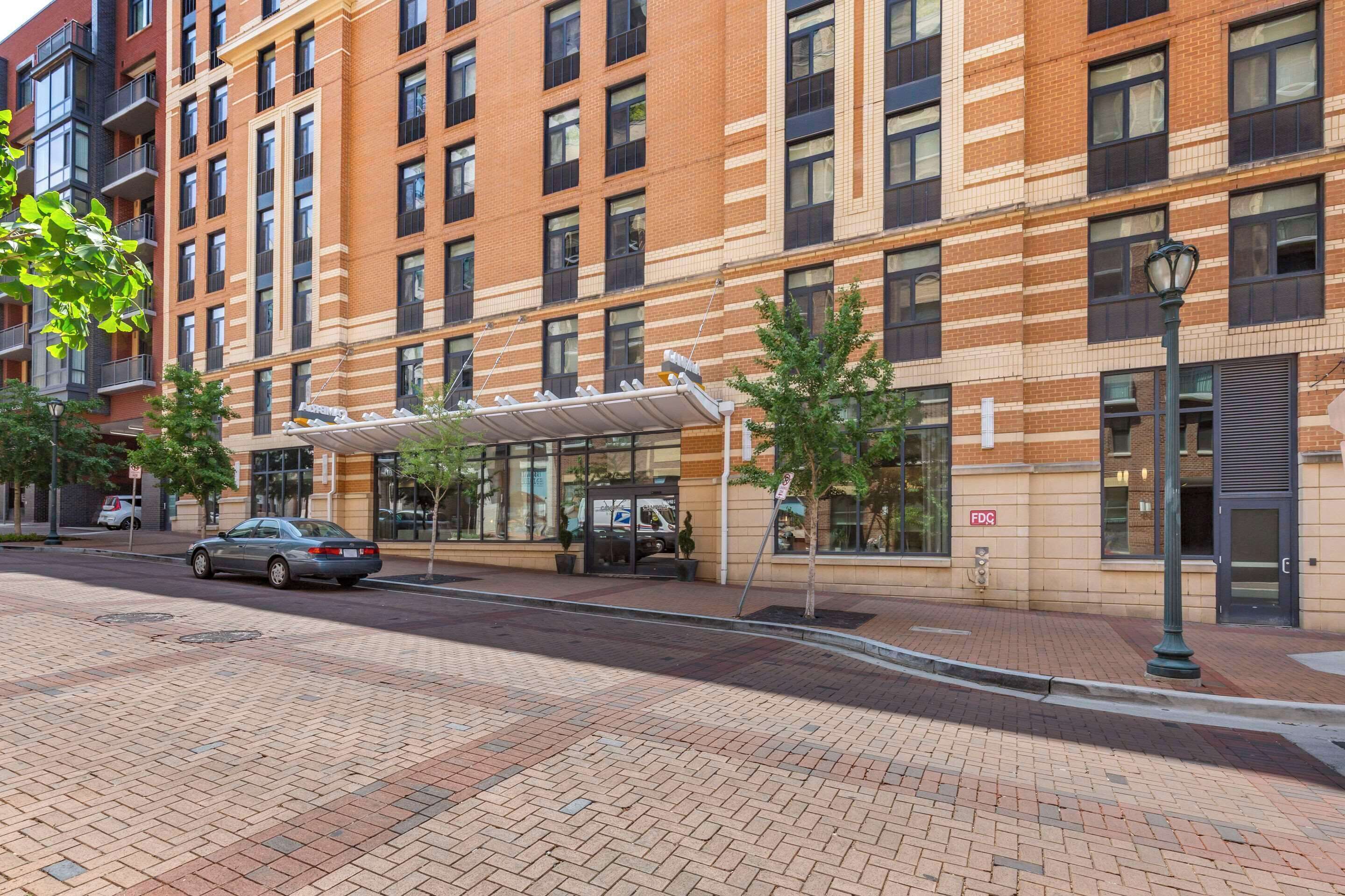 A multi-story building with a brick facade, large windows, and a covered entrance.