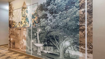 Un pasillo con un gran mural que representa un edificio y árboles.