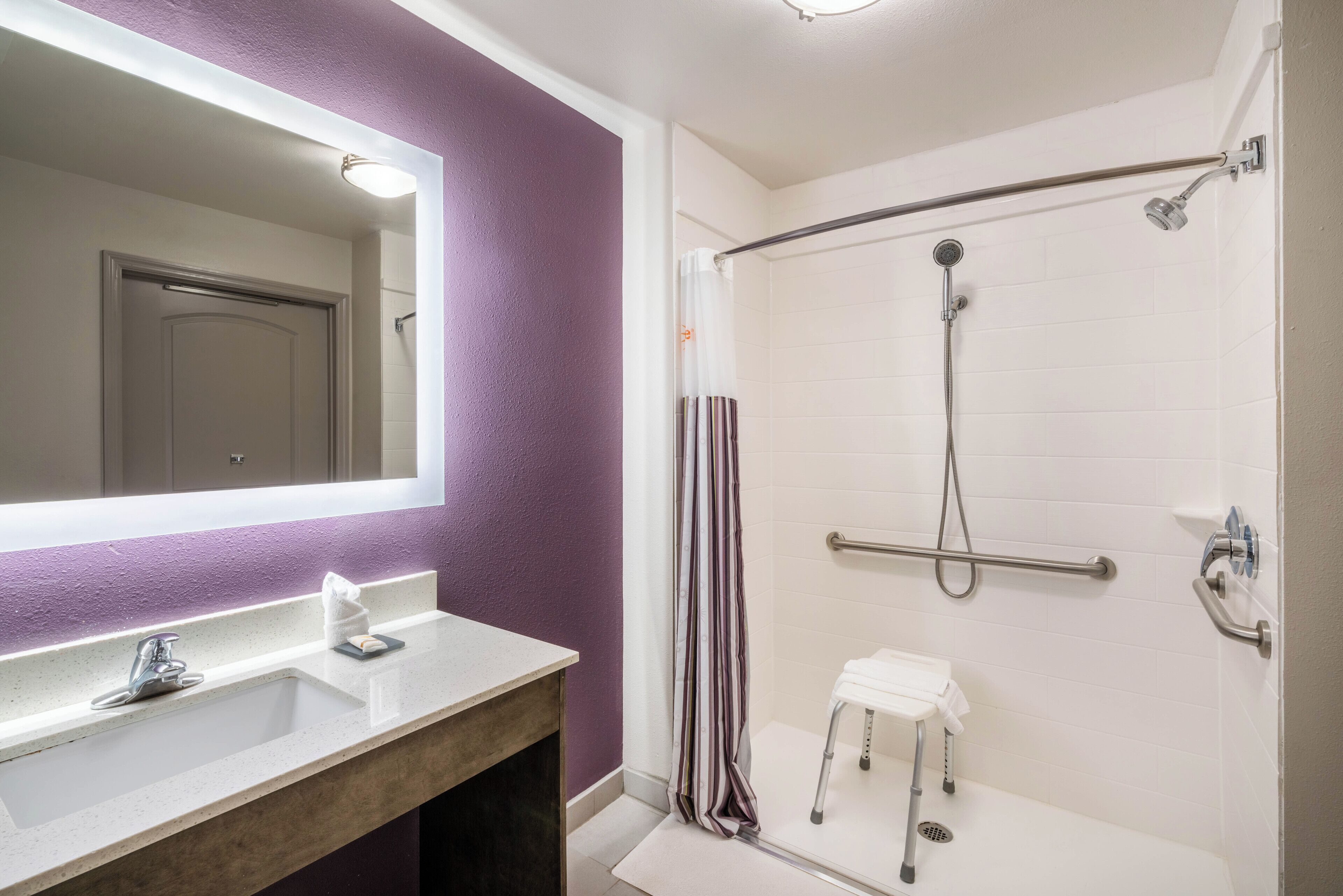 Ein Badezimmer mit weißem Waschbecken, Spiegel und Dusche.