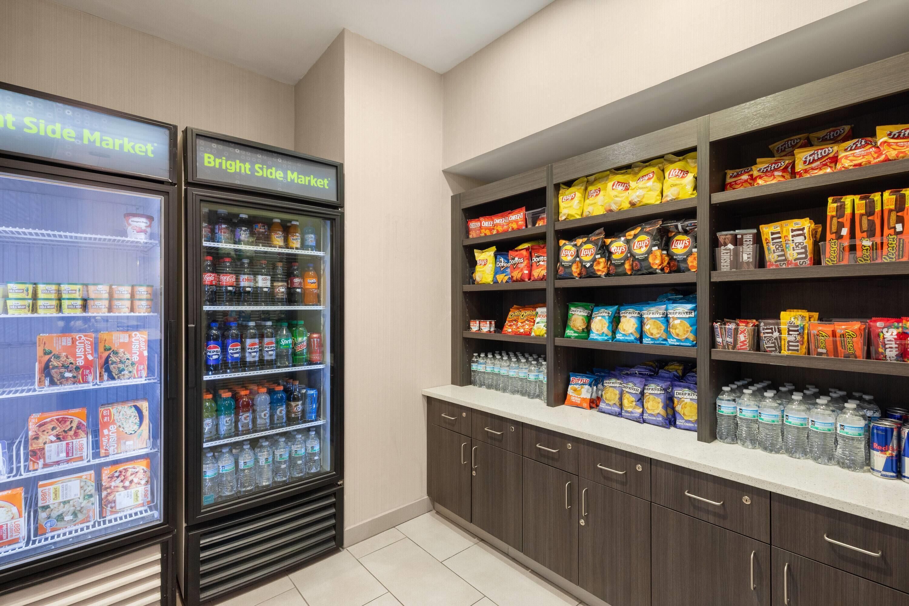 A grocery store with refrigerated sections and shelves stocked with snacks and beverages.