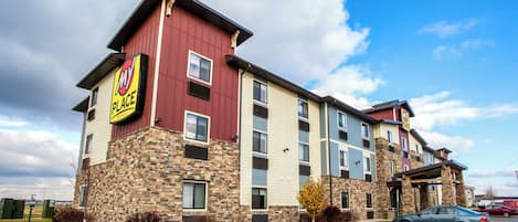 Un hôtel à plusieurs étages, doté d’une façade en pierre et d’une enseigne bien visible indiquant « MT Place ».
