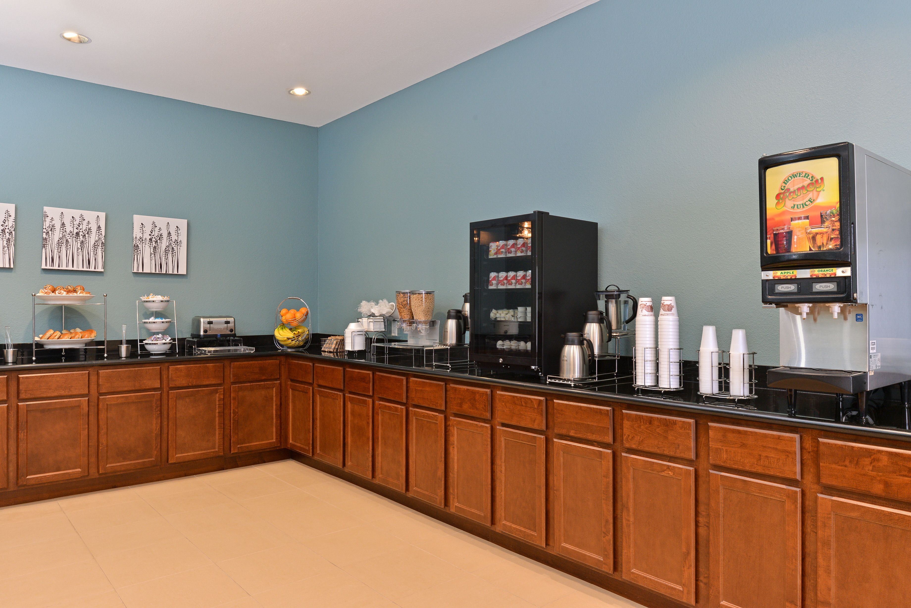 A kitchenette with a coffee machine, toaster, and various food items on the counter.