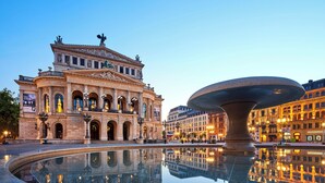 Ein historisches Gebäude mit Rundbogenfenstern und einer zentralen Fontäne.