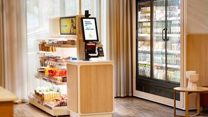 Eine Selbstbedienungs-Getränkestation mit einer gekühlten Vitrine und einem digitalen Bildschirm.