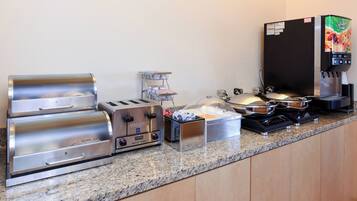 A breakfast bar with a toaster, a coffee machine, and a microwave.