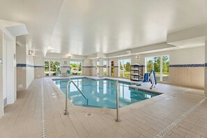 A swimming pool with a no diving sign, surrounded by a tiled floor and walls, with a view of greenery outside. - TownePlace Suites Detroit Auburn Hills (Auburn Hills)