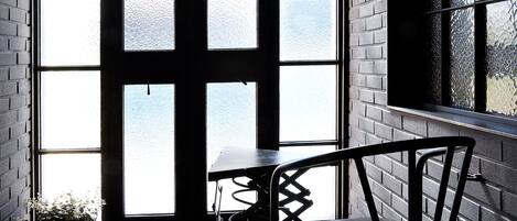 A room with a large window, a table, and a chair.